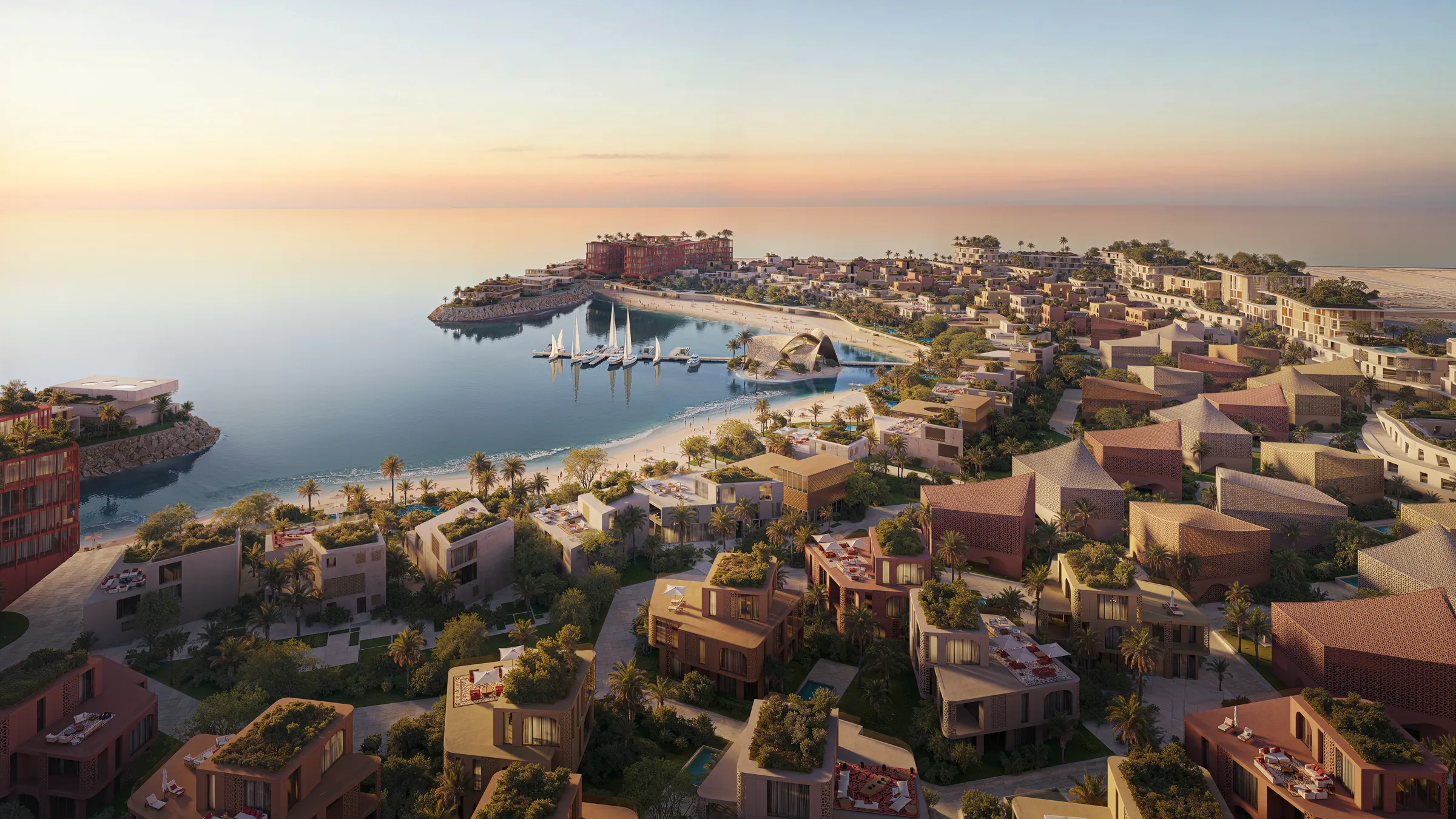 Mira Coral Bay from the air at dusk — villa clusters with planted roofs in the foreground, the beach and the marina on the headland, and the apartment buildings beyond