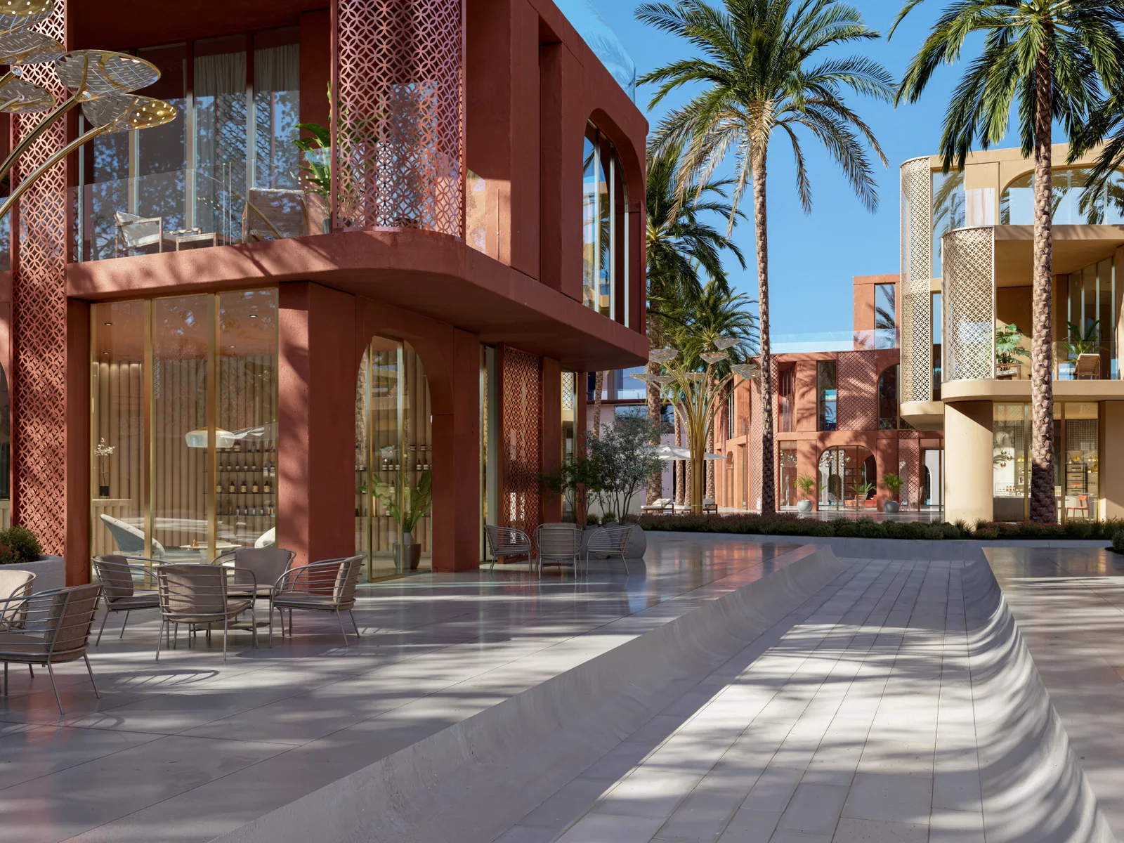 Café terrace on the plaza between the coral-red and sand-coloured buildings at Mira Coral Bay