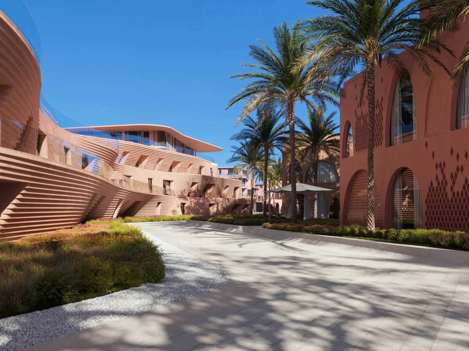Shaded walkway between the ribbed terracotta and coral-red arched facades